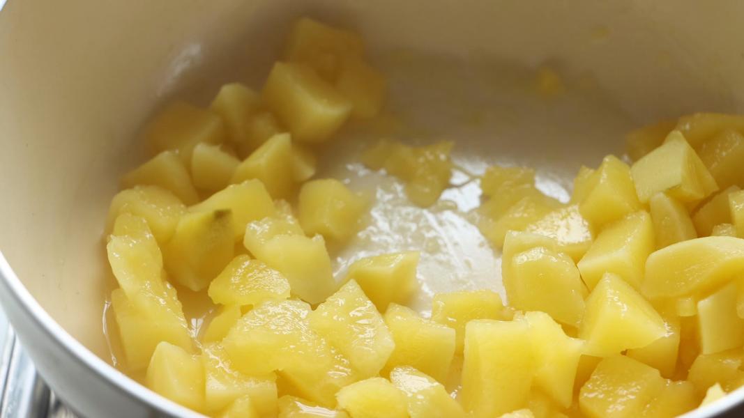 cooked mango pieces in a sauce pan