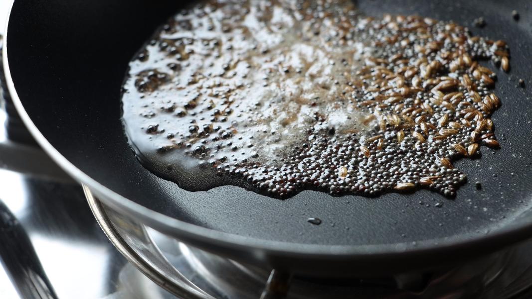 Tempering mustard seeds and cumin seeds in a small fry pan