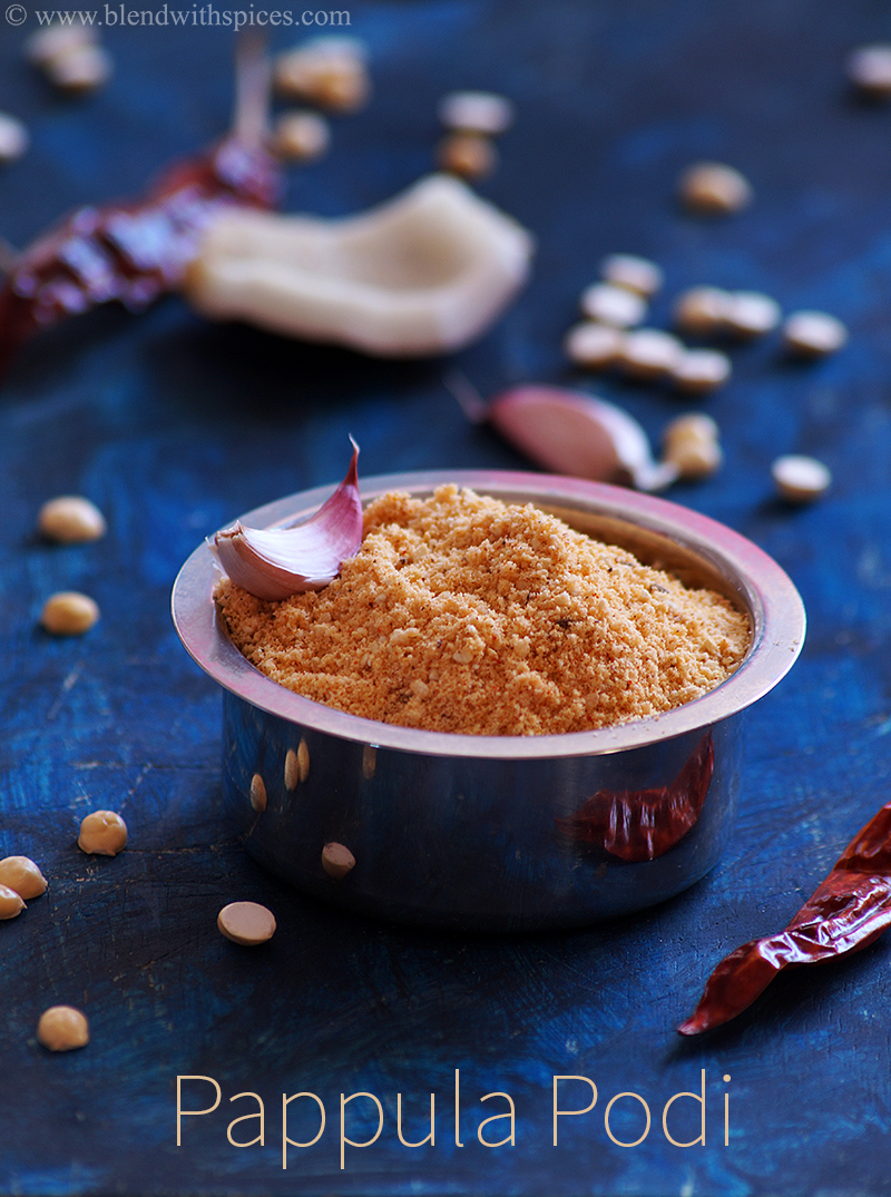 A cup of freshly ground pappula podi garnished with garlic