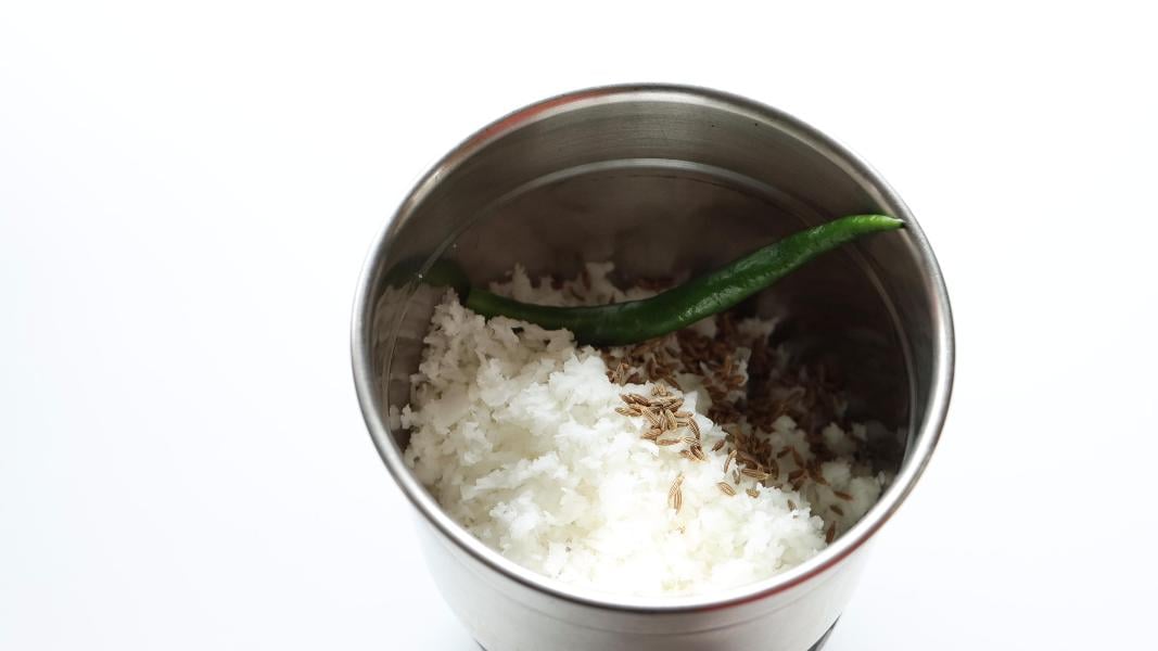 fresh coconut, cumin seeds and green chilli in a blender jar
