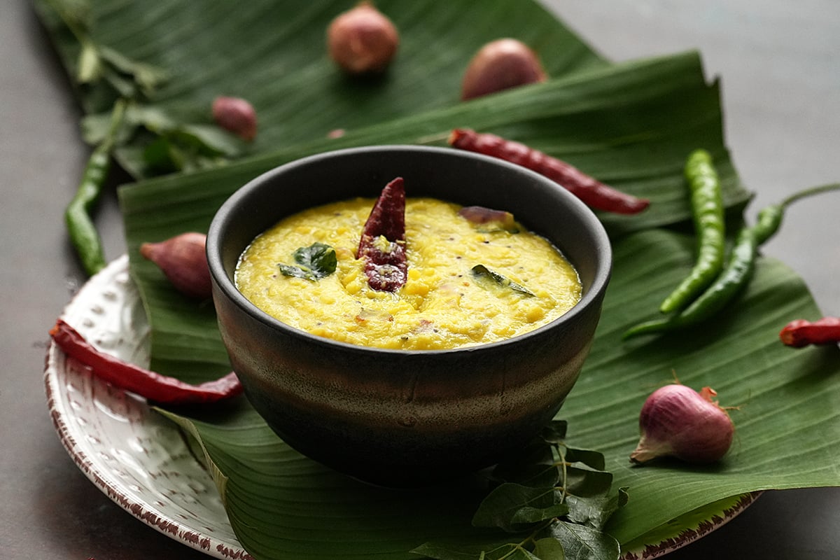 A bowl full of classic parippu curry topped with red chilli and curry leaves