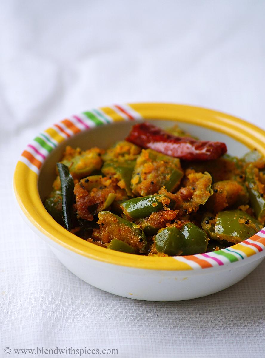 capsicum besan curry topped with curry leaves and red chilli served in a bowl with white background