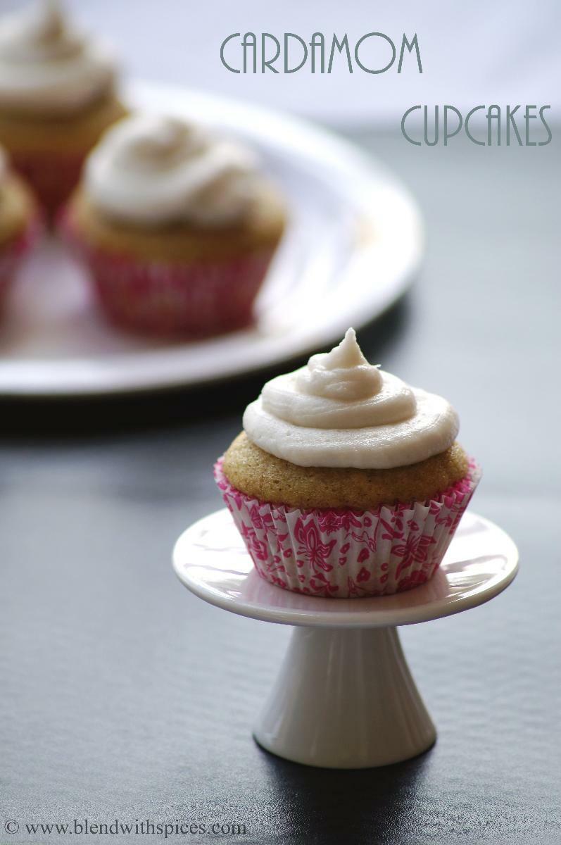 Vegan cardamom cupcake with vanilla frosting placed on a small cupcake stand