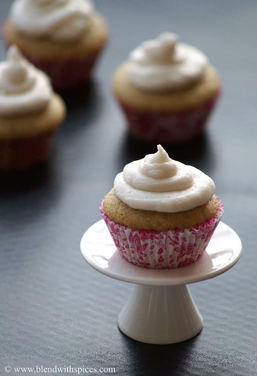 Vegan cardamom cupcake with vanilla frosting placed on a small cupcake stand