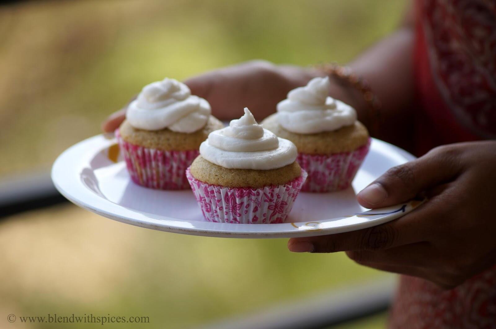 Eggless cardamom cupcakes with frosting serving on a plate