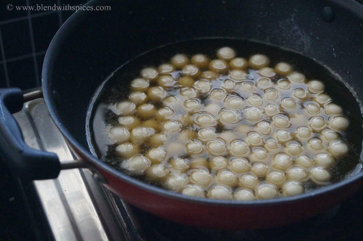 Rice flour dumplings simmering in jaggery syrup until they become soft and cooked for paal kozhukattai.
