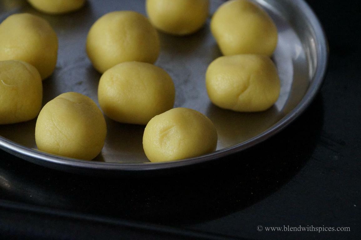 Kesar peda mixture divided and shaped into smooth round balls.