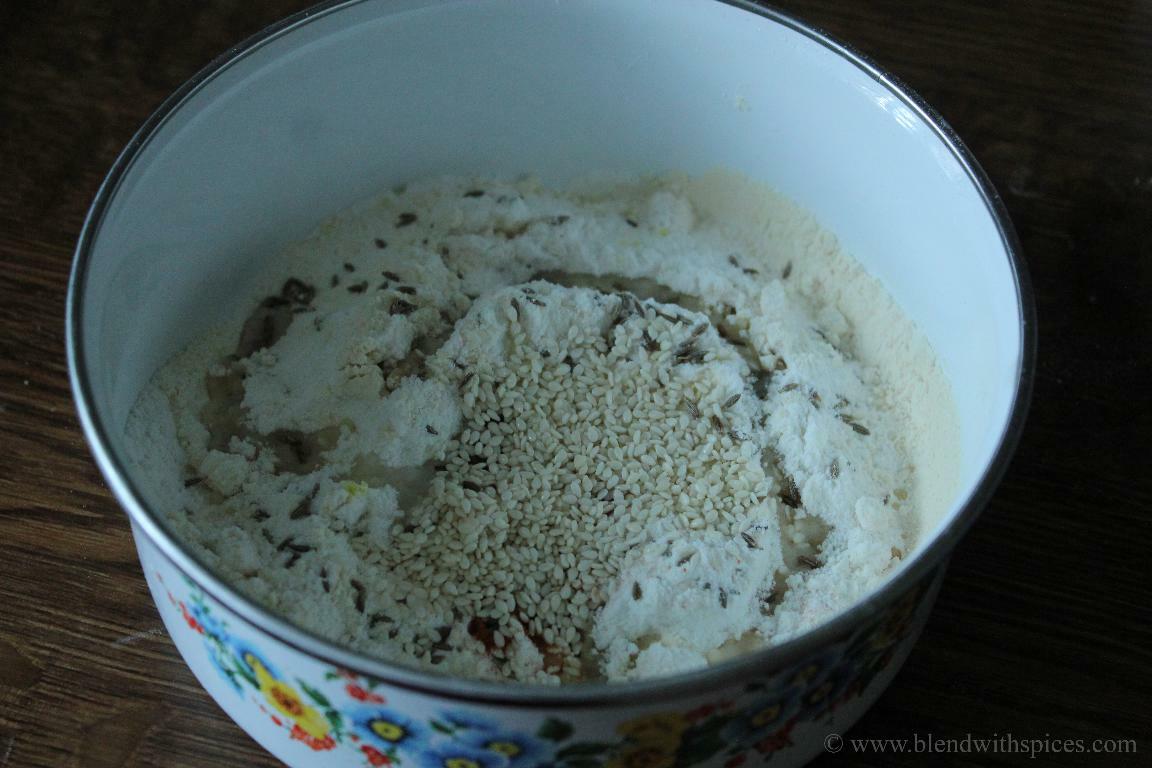 Rice flour, roasted gram flour, red chili powder, salt, cumin seeds, oil, hing and sesame seeds are added to a mixing bowl