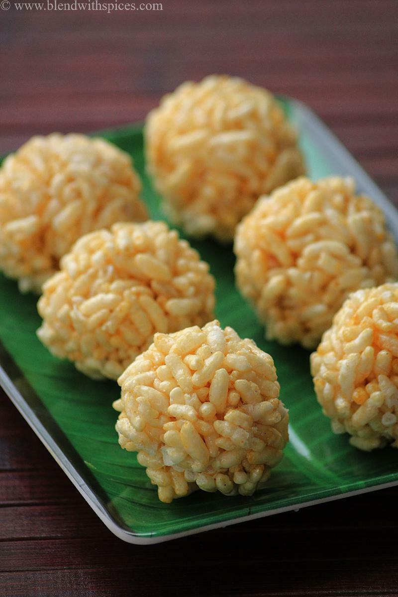 Homemade pori urundai / murmura laddu made with puffed rice and jaggery, shaped into round balls and served on a green plate.