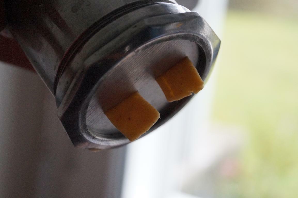 Ribbon pakoda dough pressed through a murukku maker with ribbon-shaped disc.