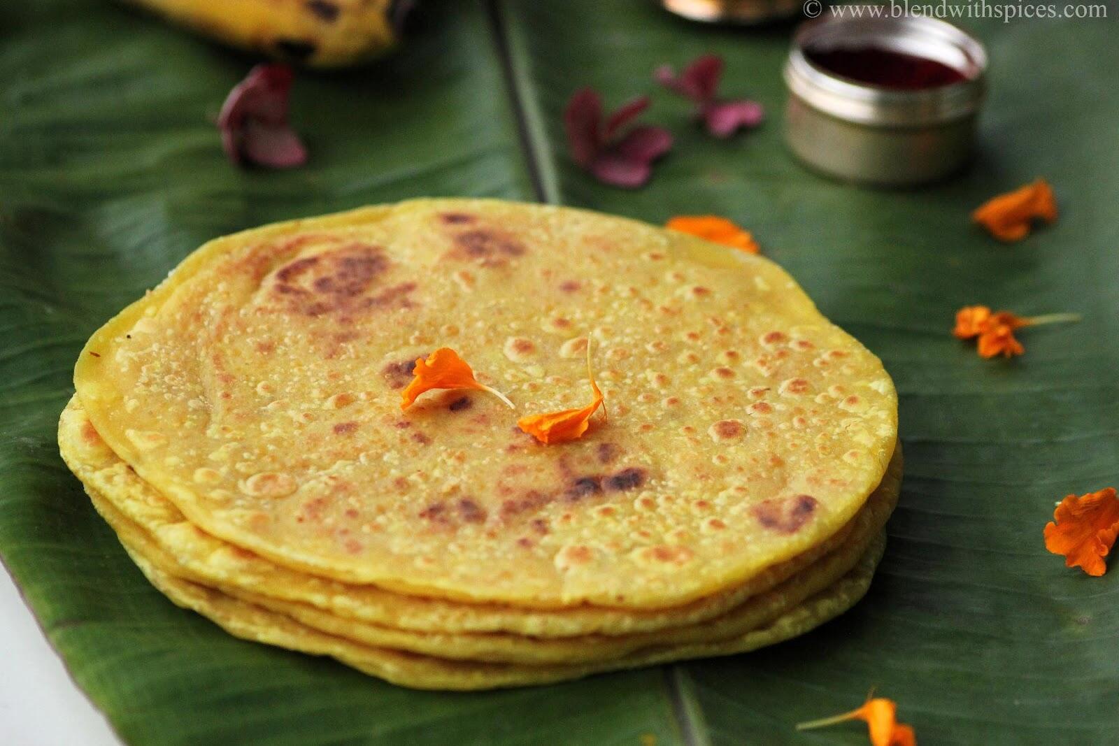 A stack of traditional South Indian kayi holige or coconut obbattu served on a green banana leaf