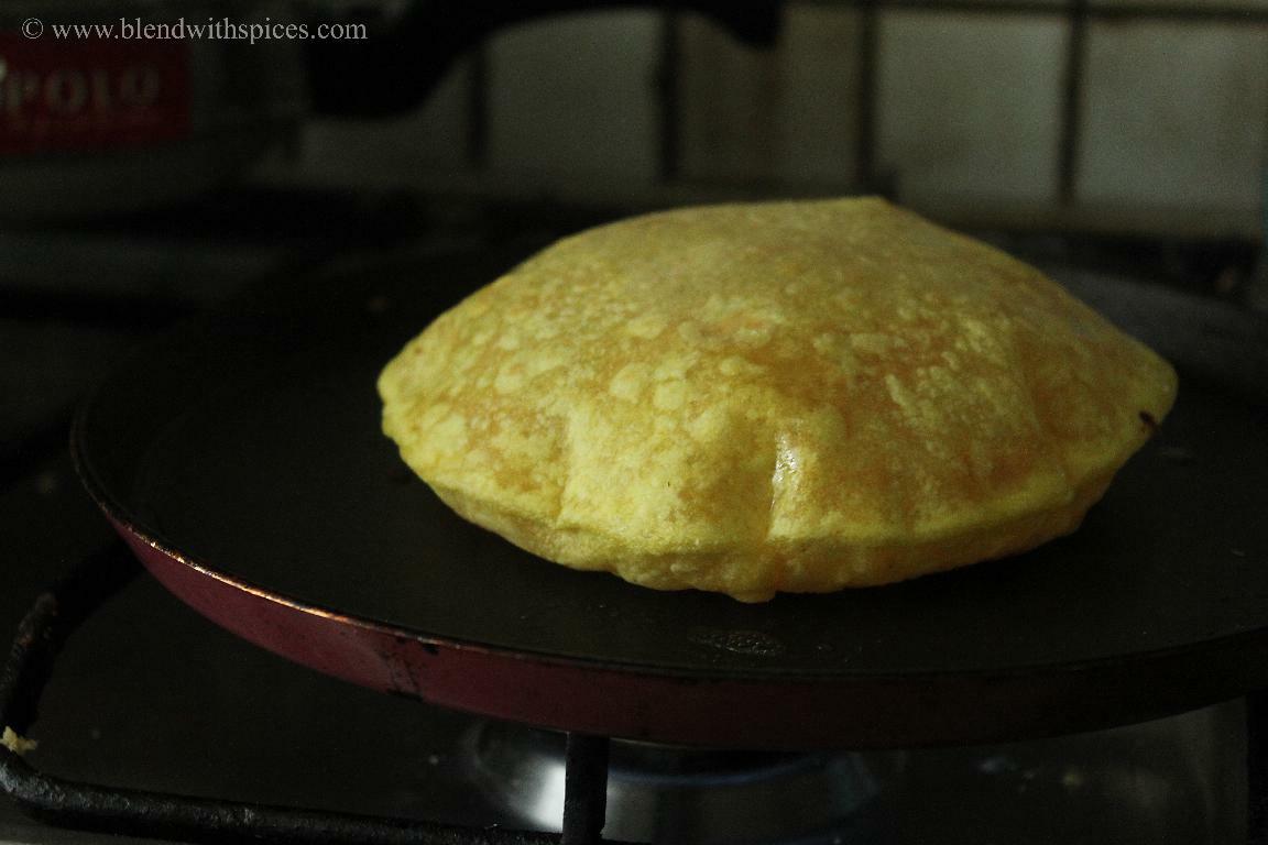 Cooking kayi holige on a pan until it puffs and turns golden