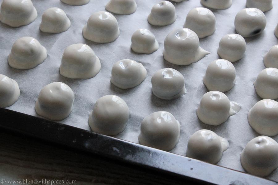 yogurt coated blueberries are arranged on a parchment paper