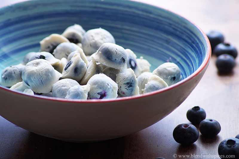 yogurt covered blueberries served in a blue bowl