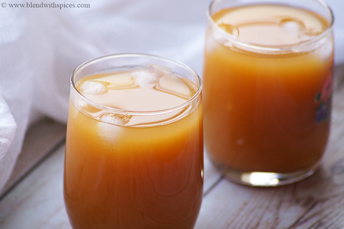 side angle of two glasses of mango iced drink served with ice cubes
