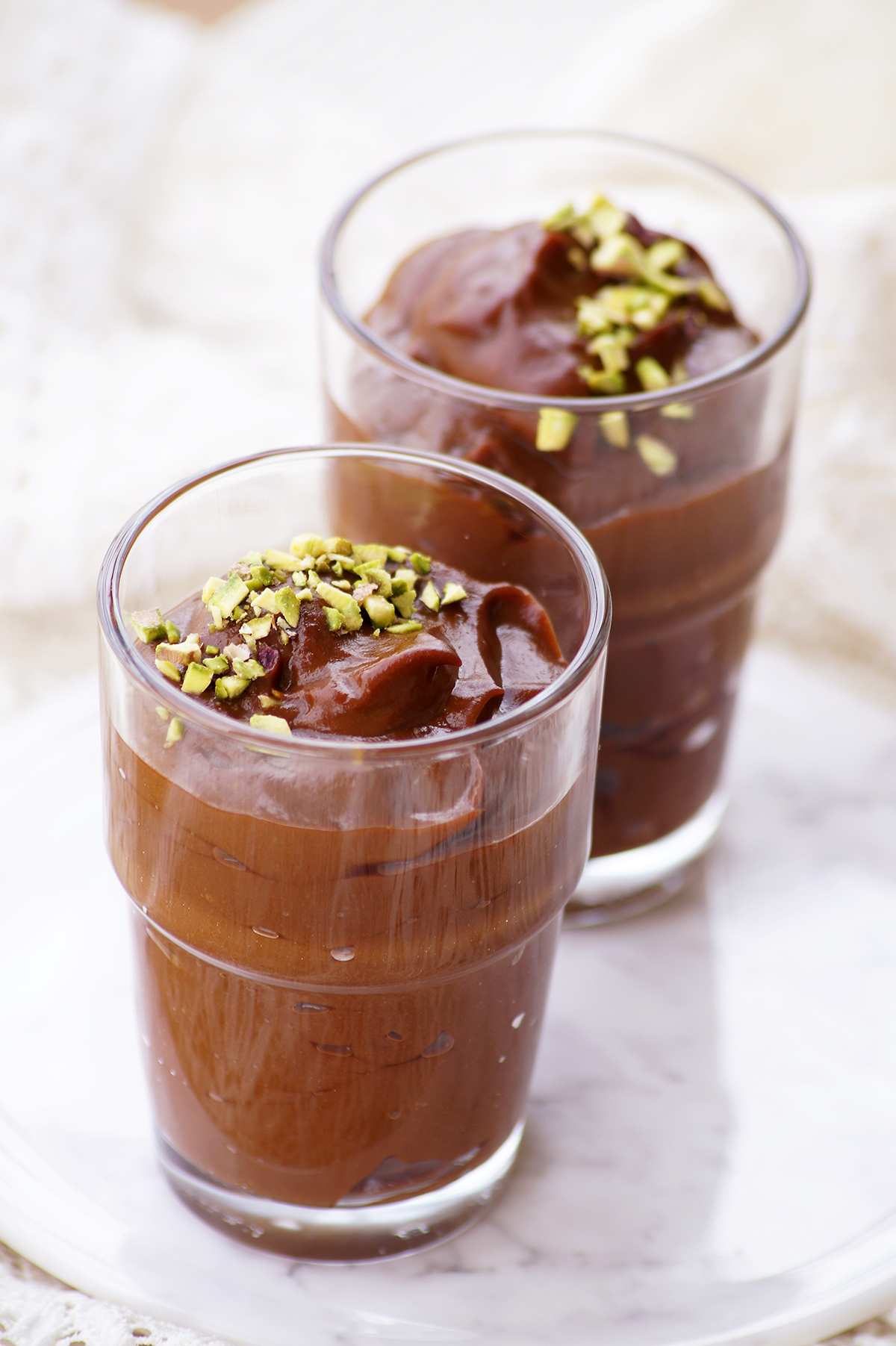 dutch coffee custard served in 2 serving glasses topped with chopped pistachios