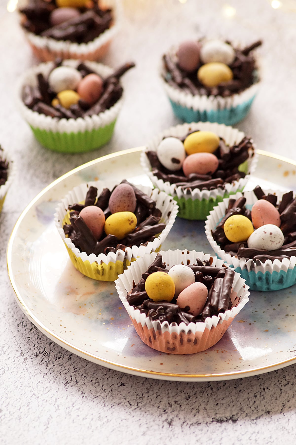 A few pieces of Chocolate Pretzel Easter Nests topped with mini eggs in muffin liners.