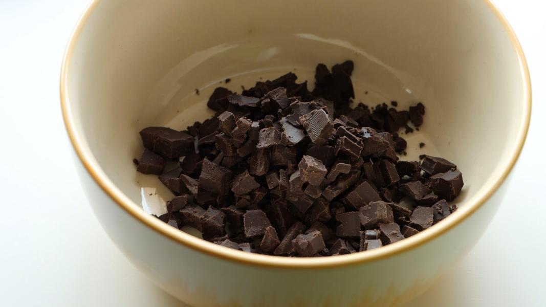 Chopped chocolate added to a microwave-safe bowl to melt to make easter nests.