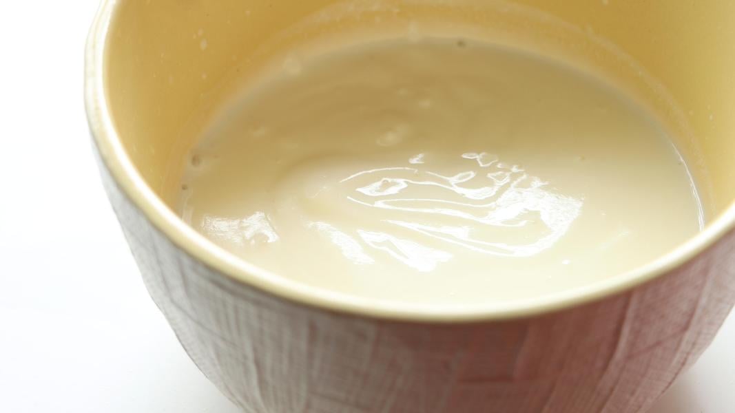 whisked yogurt in a yellow mixing bowl
