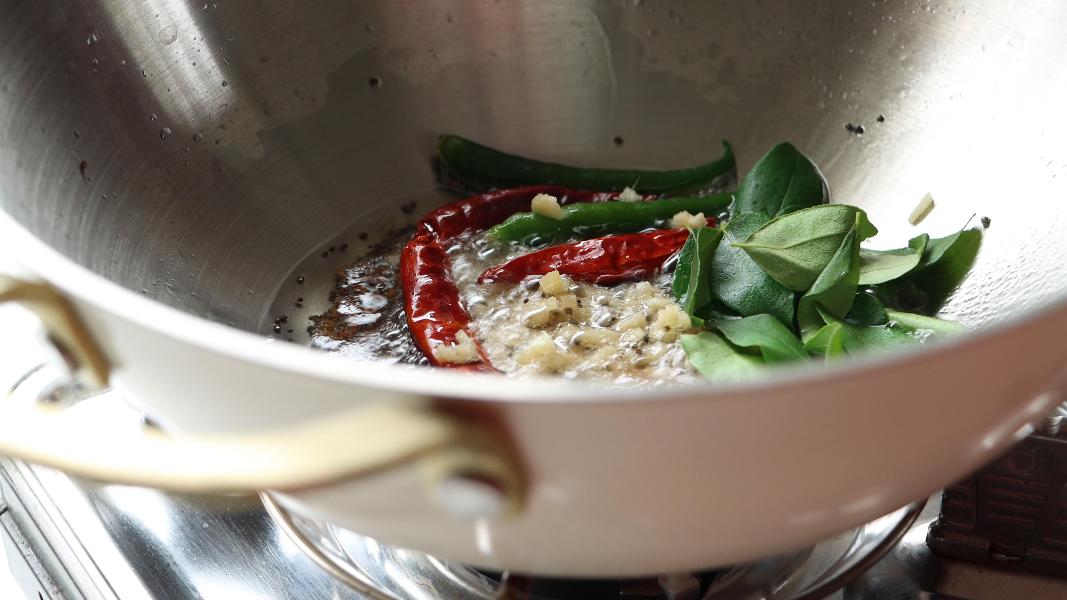tempering spices and herbs in a kadai