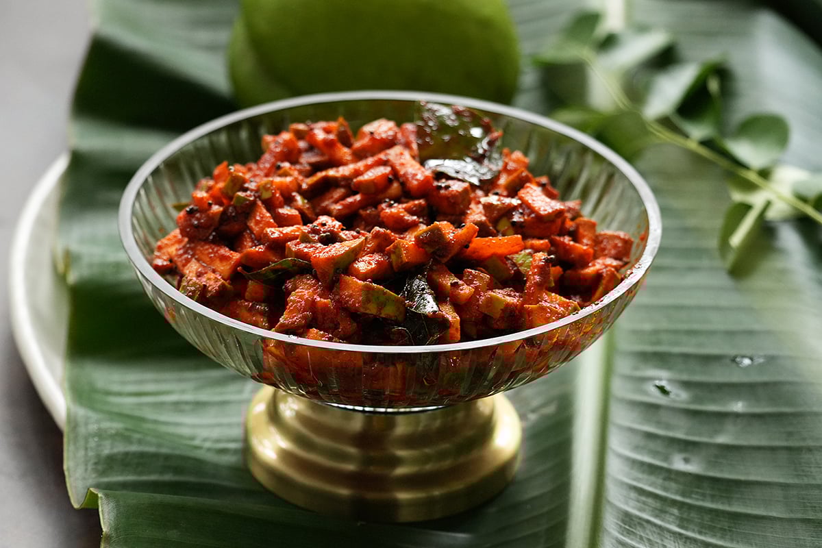 kerala instant mango pickle in a glass bowl on a banana leaf