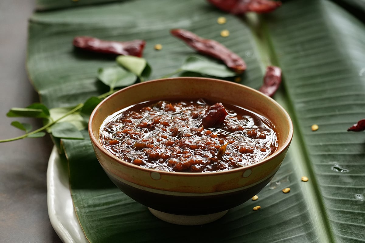 a small bowl of inji puli on a banana leaf