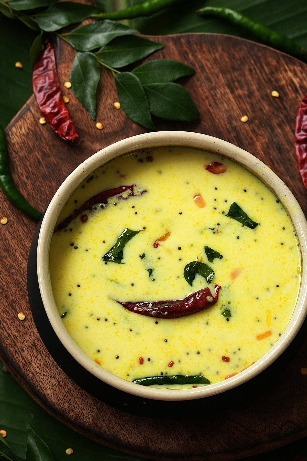 A bowlful of kerala style moru curry on a wooden board 