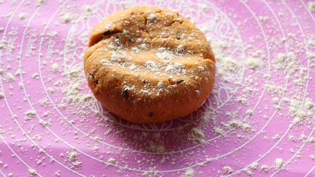 A portion of the dough ball is placed on a work surface to roll.