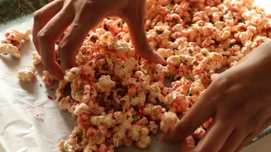 Breaking apart prepared popcorn into pieces using hands