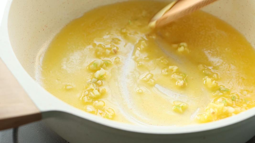 Sauteeing minced garlic in melted butter for parmesan rice.