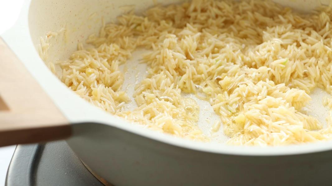 Sauteeing rice in the garlic butter mixture before adding milk and water.