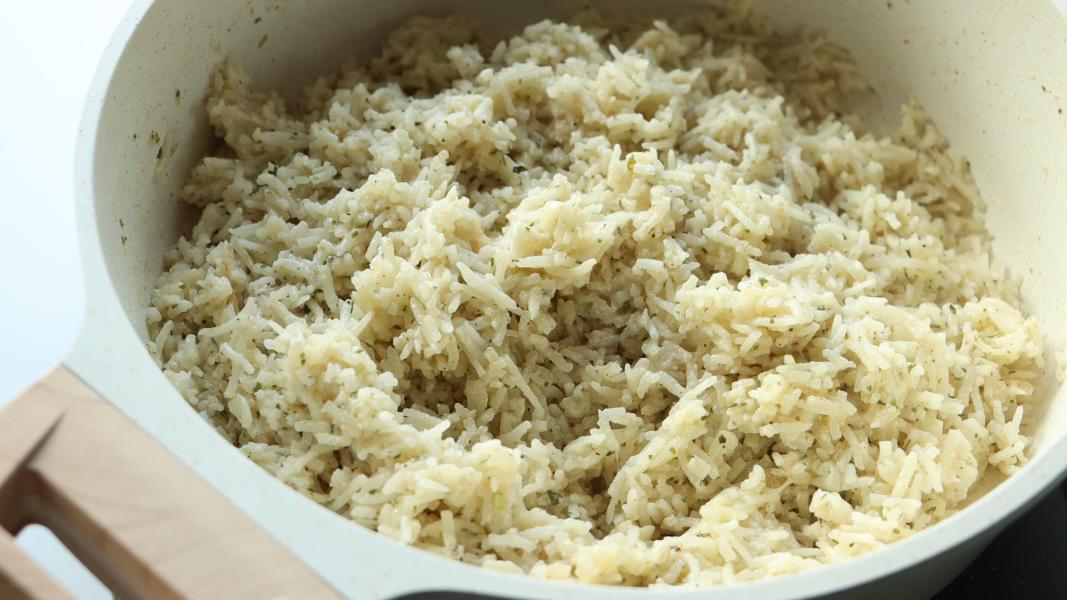 Fluffing rice with a fork when it is still hot.