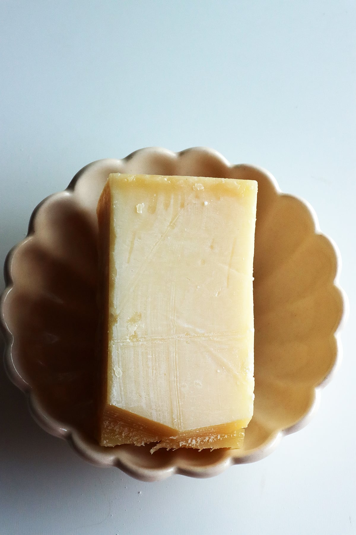 A block of parmesan cheese ready to be grated to make parmesan rice.